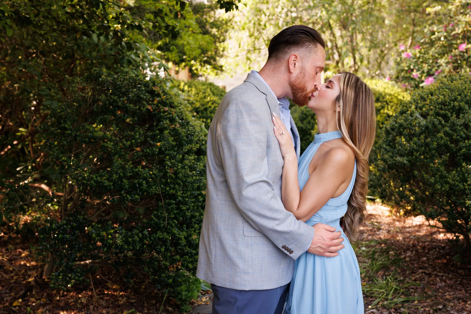 Close portrait of a couple about to kiss in the gardens at Planting Fields Arboretum, her hair and makeup photographed in natural light, engagement session by George Pompilio