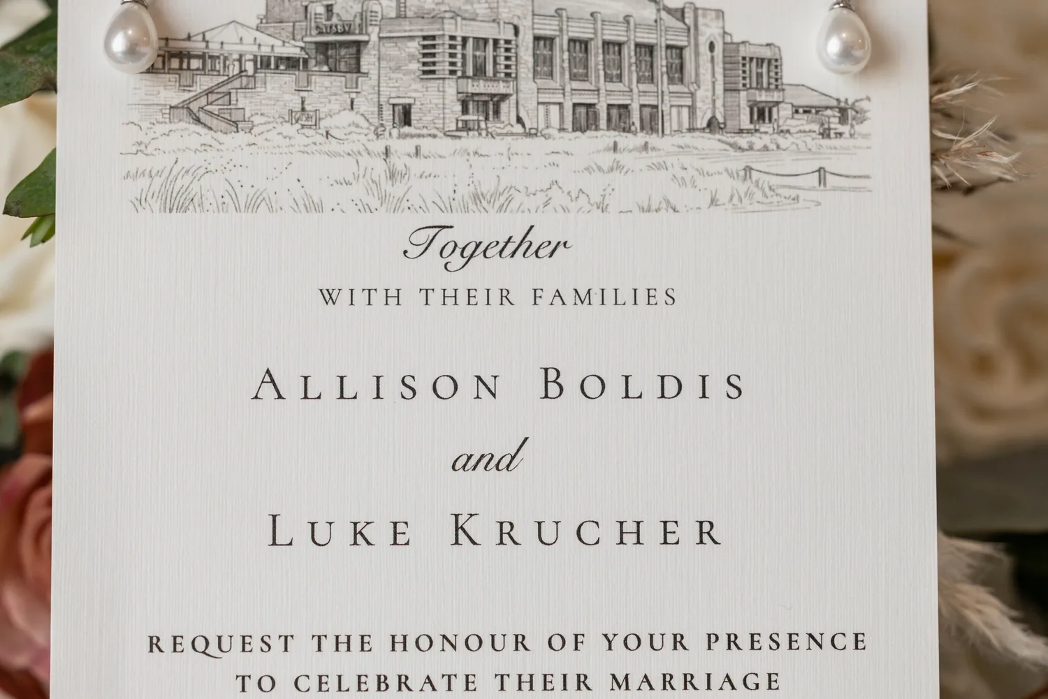 Allison and Luke&rsquo;s wedding invitation with a sketch of Gatsby On The Ocean and pearl earrings &mdash; George Pompilio Photography