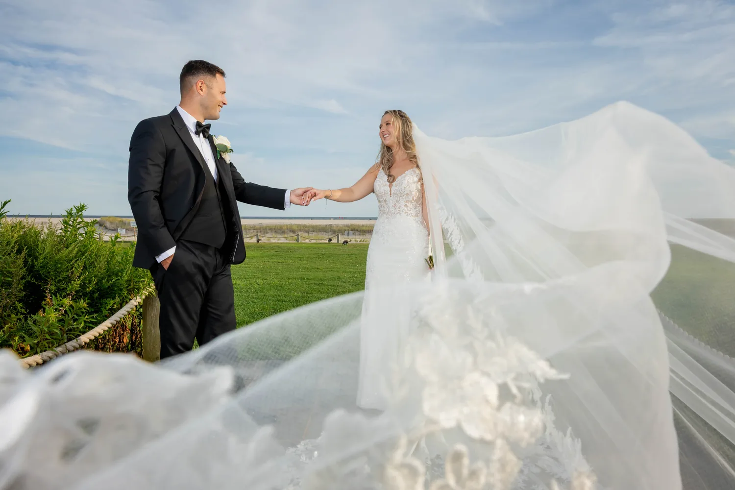 Luke reaching for Allison&rsquo;s hand as her veil fills the frame at Gatsby On The Ocean &mdash; George Pompilio Photography