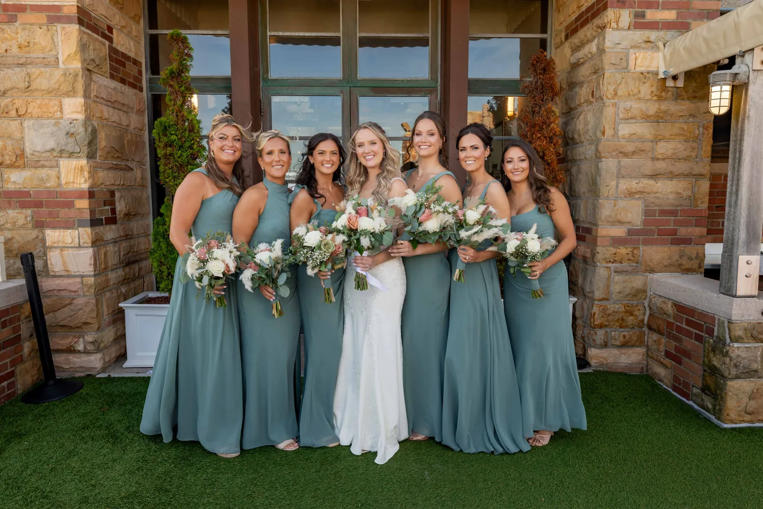 Allison with her bridesmaids in sage green on the terrace at Gatsby On The Ocean &mdash; George Pompilio Photography