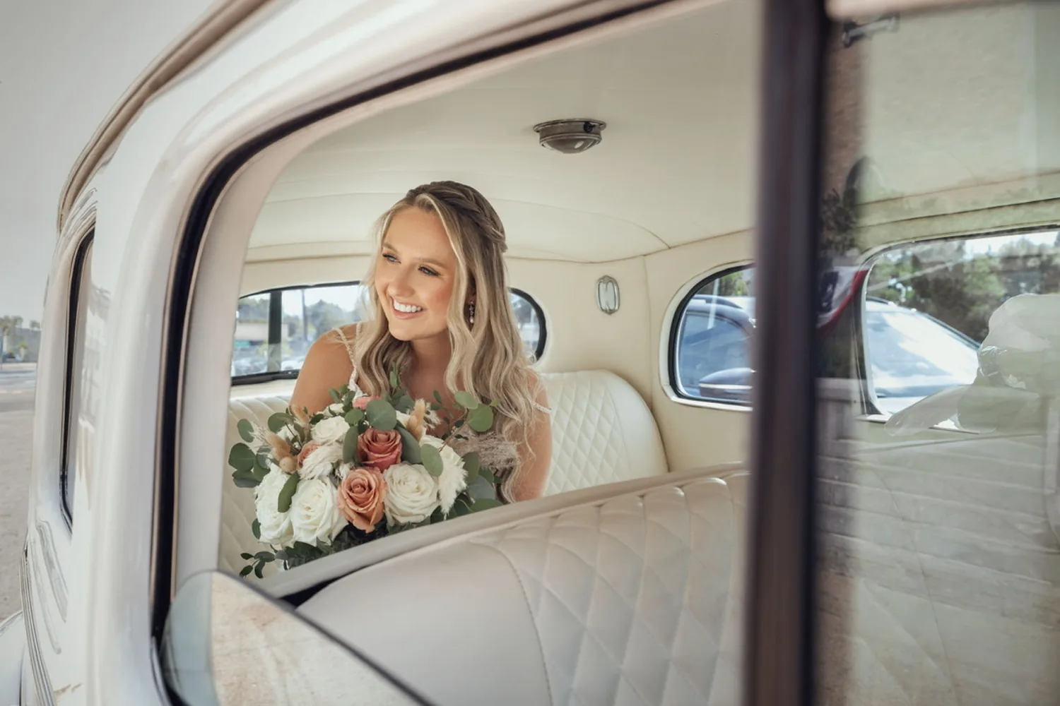 Allison smiling with her bouquet in the back seat of a vintage white car before the ceremony &mdash; George Pompilio Photography