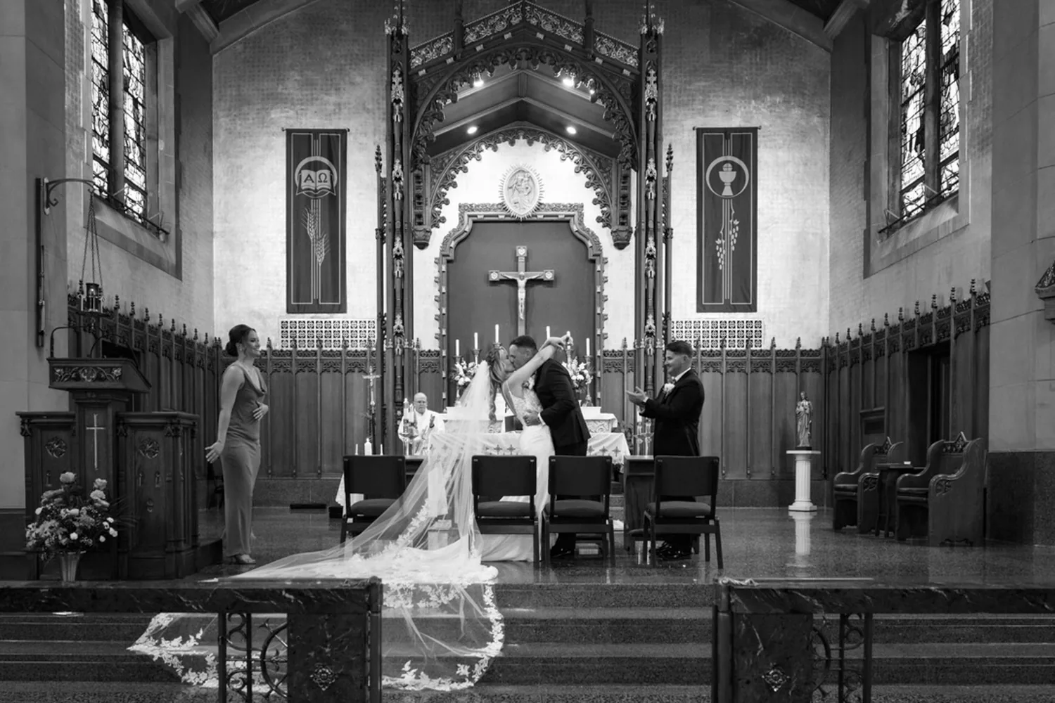 Black and white of Allison and Luke&rsquo;s first kiss at the altar of The Church of St. Christopher &mdash; George Pompilio Photography
