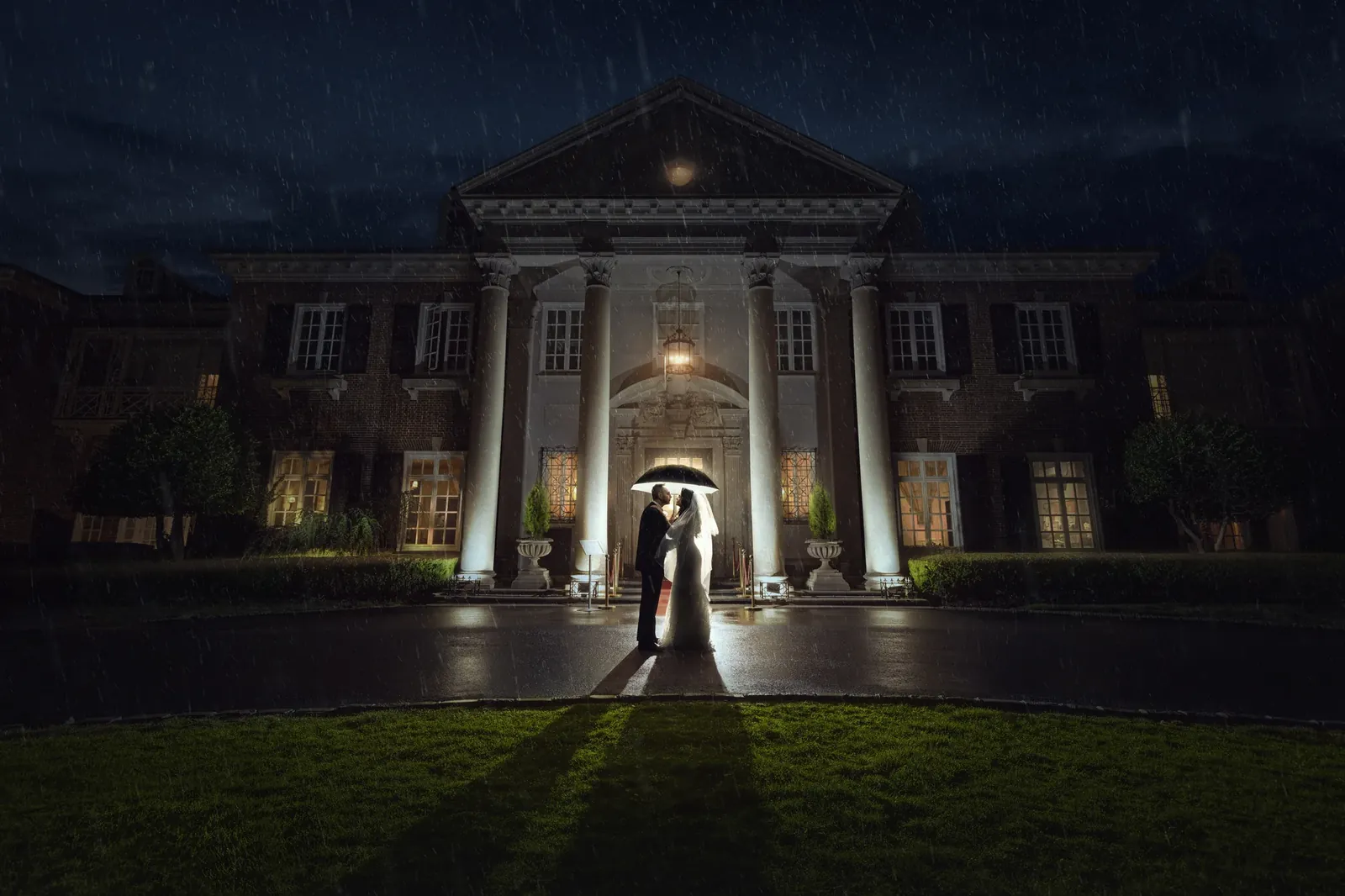 Bride and groom under umbrella in the rain at Glen Cove Mansion — George Pompilio Photography