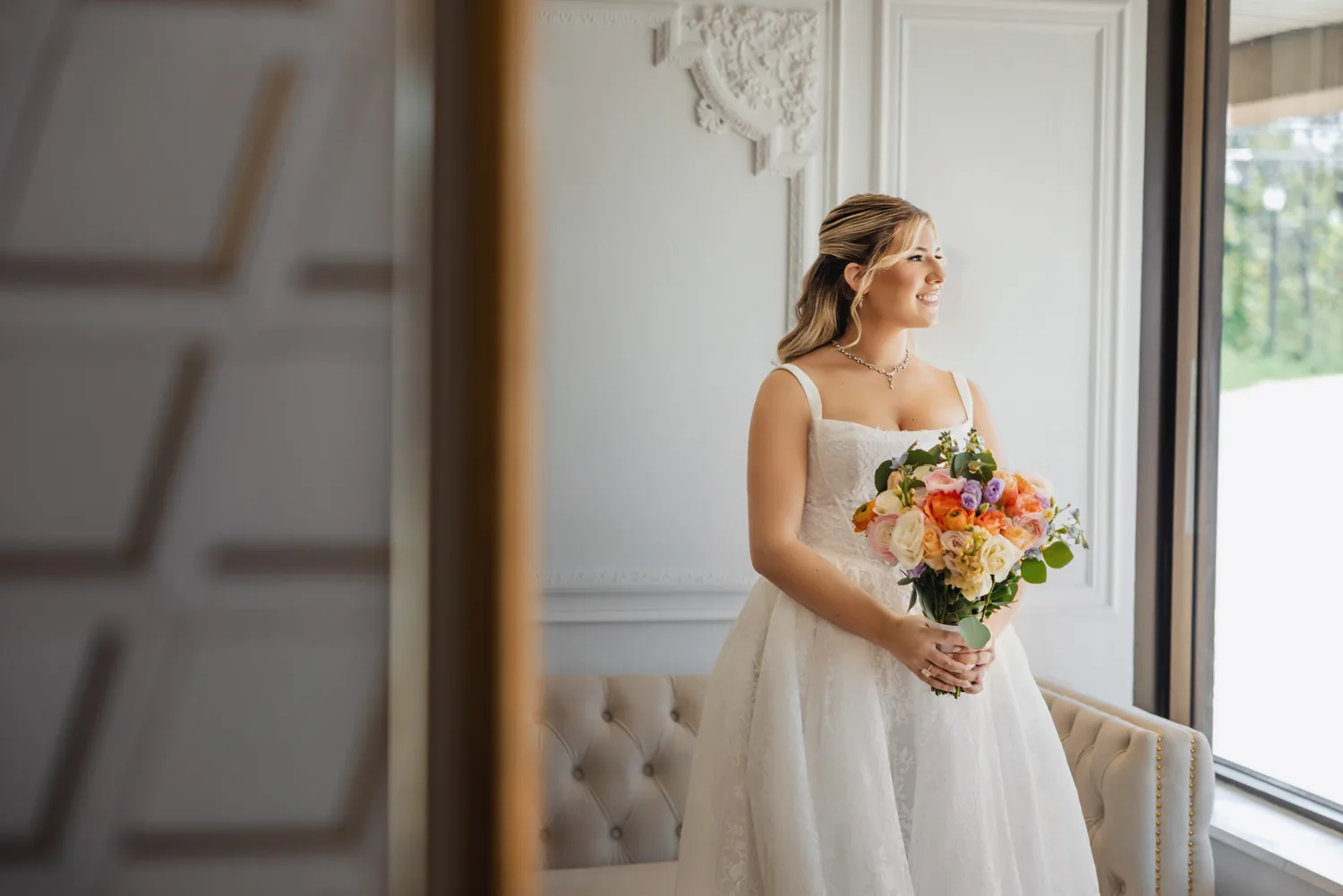 Chelsea and Ryan&rsquo;s wedding: Bride by the window in a light-filled room at Larkfield, East Northport &mdash; George Pompilio Photography
