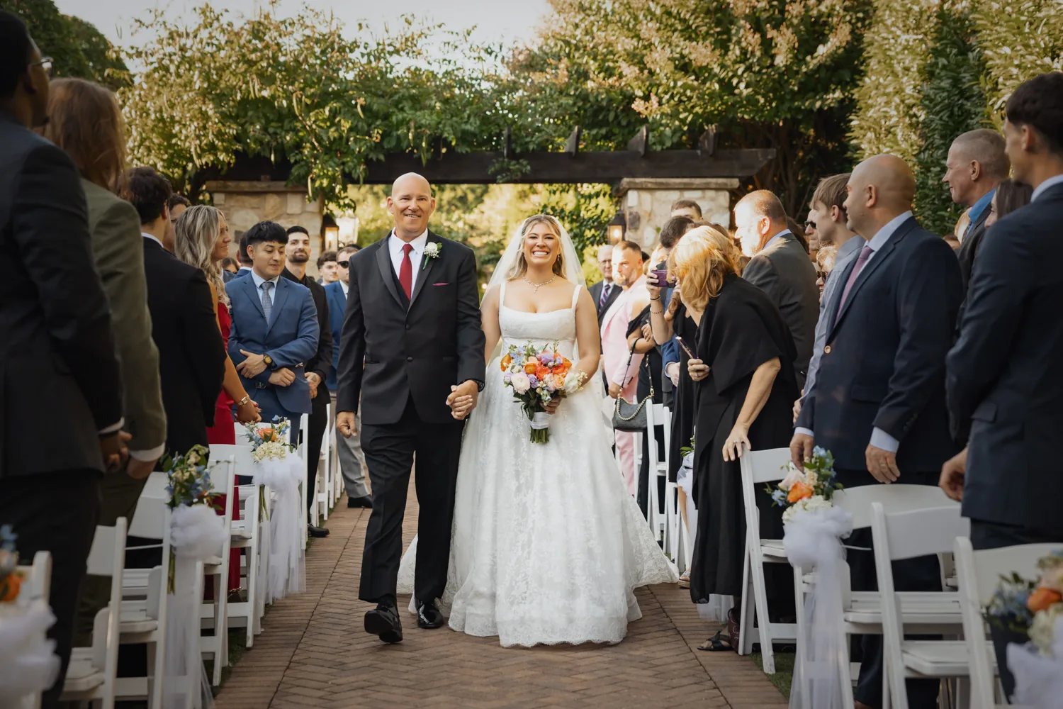 Chelsea and Ryan&rsquo;s wedding: Bride walking down the aisle with her father at the Larkfield garden ceremony &mdash; George Pompilio Photography