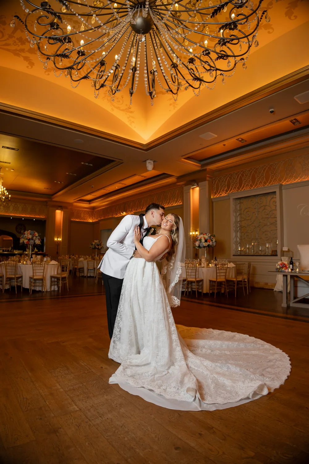 Chelsea and Ryan&rsquo;s wedding: Bride and groom kissing under the chandelier in the Larkfield ballroom &mdash; George Pompilio Photography